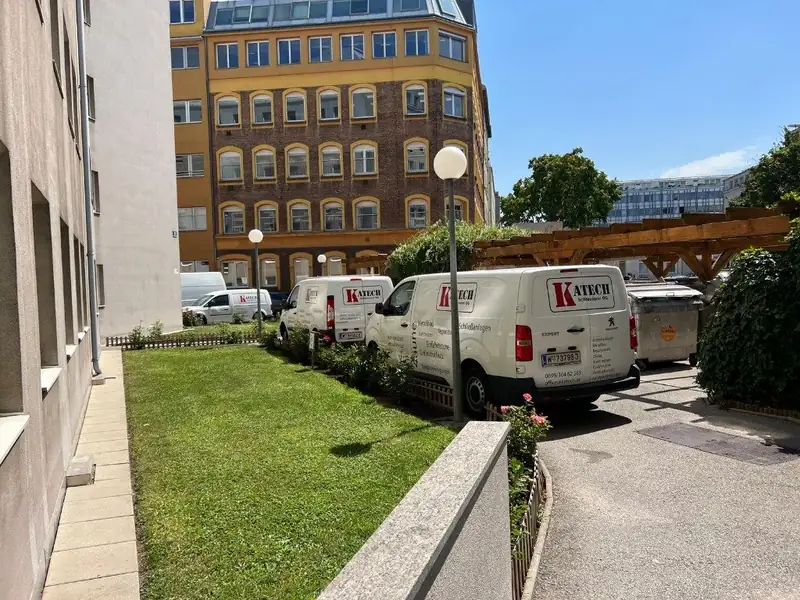 Drei weiße Katech-Servicefahrzeuge vor dem Betriebsgelände in Wien